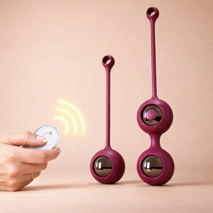 Elegant wine-red silicone Kegel exercise ball with dual-weight system, placed on a matching velvet fabric for women’s intimate pelvic floor training.
