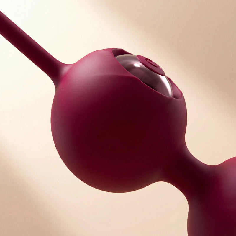 Extreme close-up macro shot highlighting the ultra-smooth, hypoallergenic medical-grade silicone texture of the wine-red 2-in-1 Kegel exercise ball, emphasizing its seamless, body-safe design for intimate wellness.