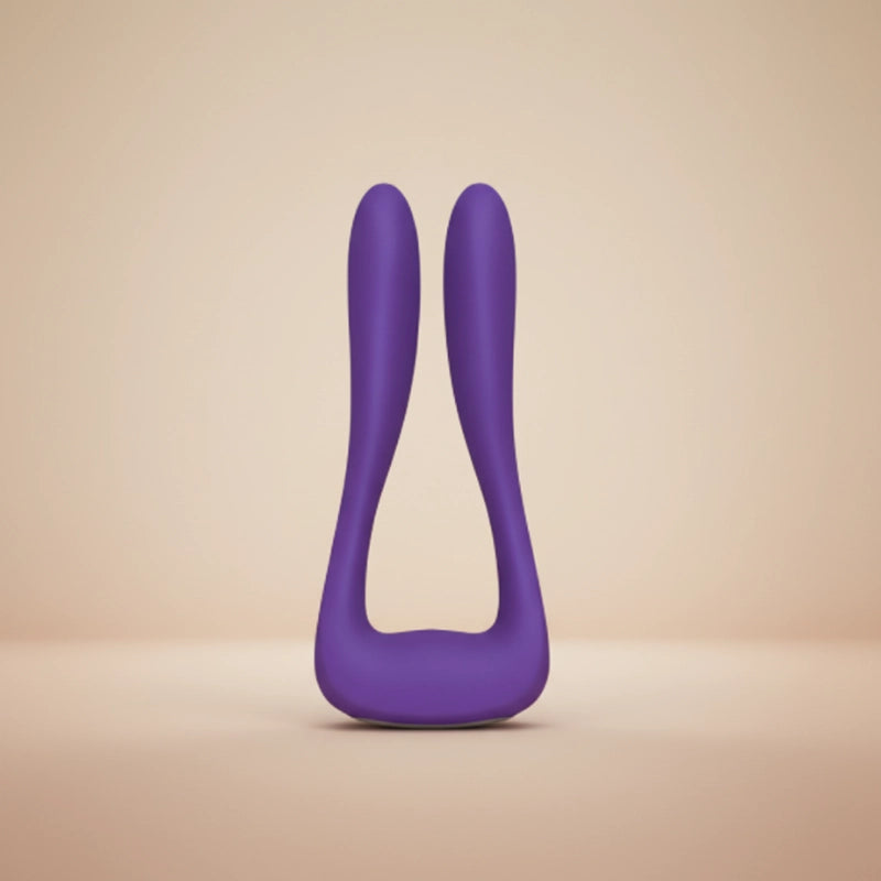 Elegant rose-purple silicone wellness device floating in soft diffused studio light against a white-to-blush gradient background.
