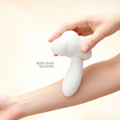 Hand holding a mushroom-style dual stimulator on the arm to show its scale and soft-touch, body-safe silicone material in a front-view demonstration.