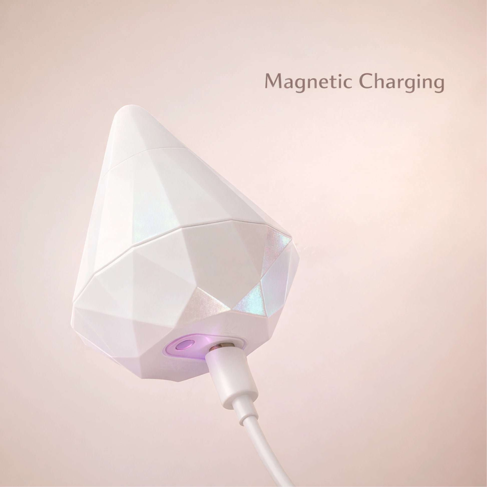 Side view of the pearl white diamond stimulator connected to its magnetic charger, showcasing the easy-to-use and hassle-free charging system for reliable power.
