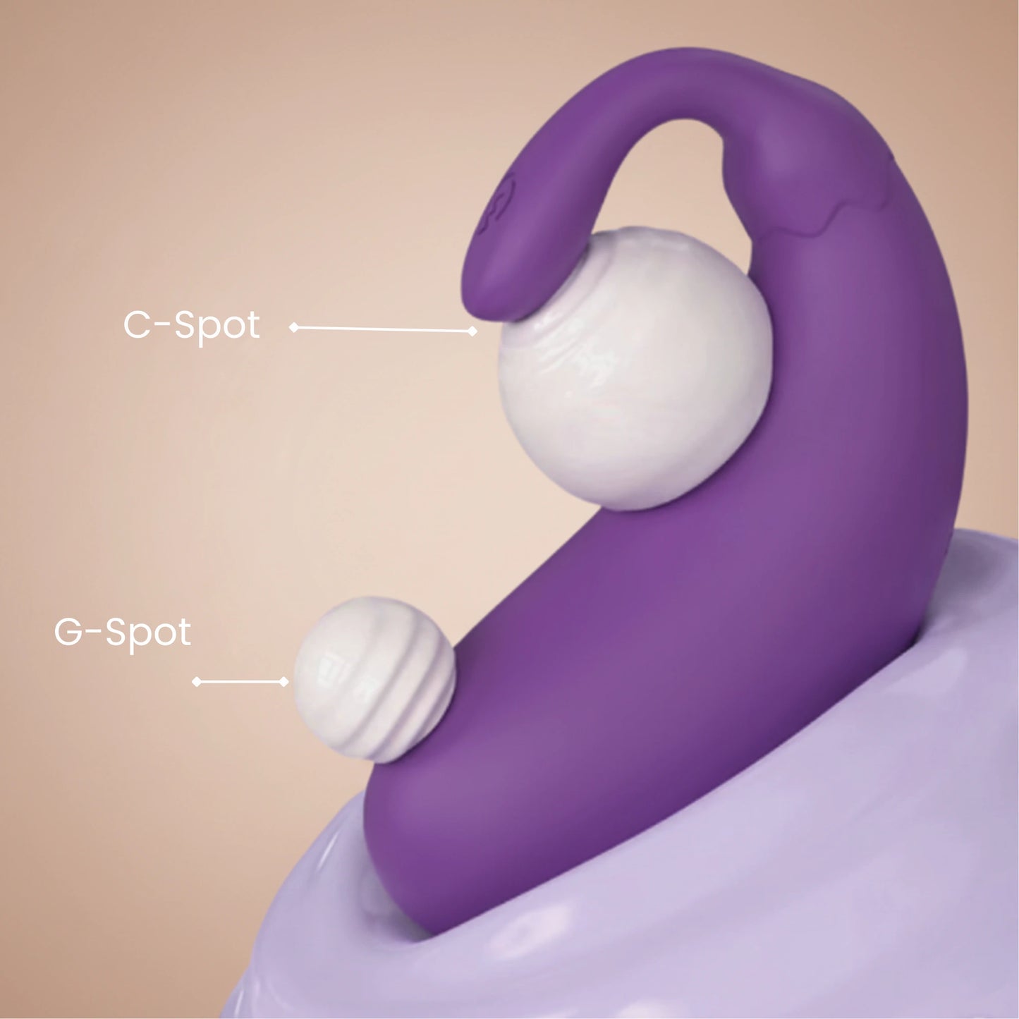 Purple and white sexual wellness device with labeled C-Spot and G-Spot on a beige background