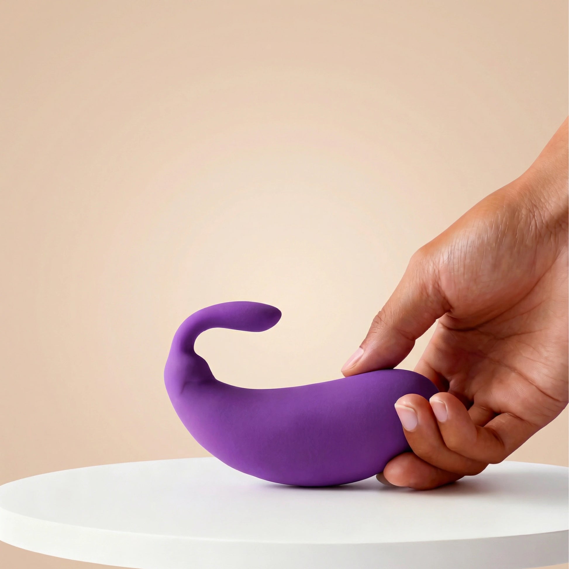 Front view of the playful purple mini eggplant vibrator held comfortably in a hand, showcasing its compact and discreet size for personal use.
